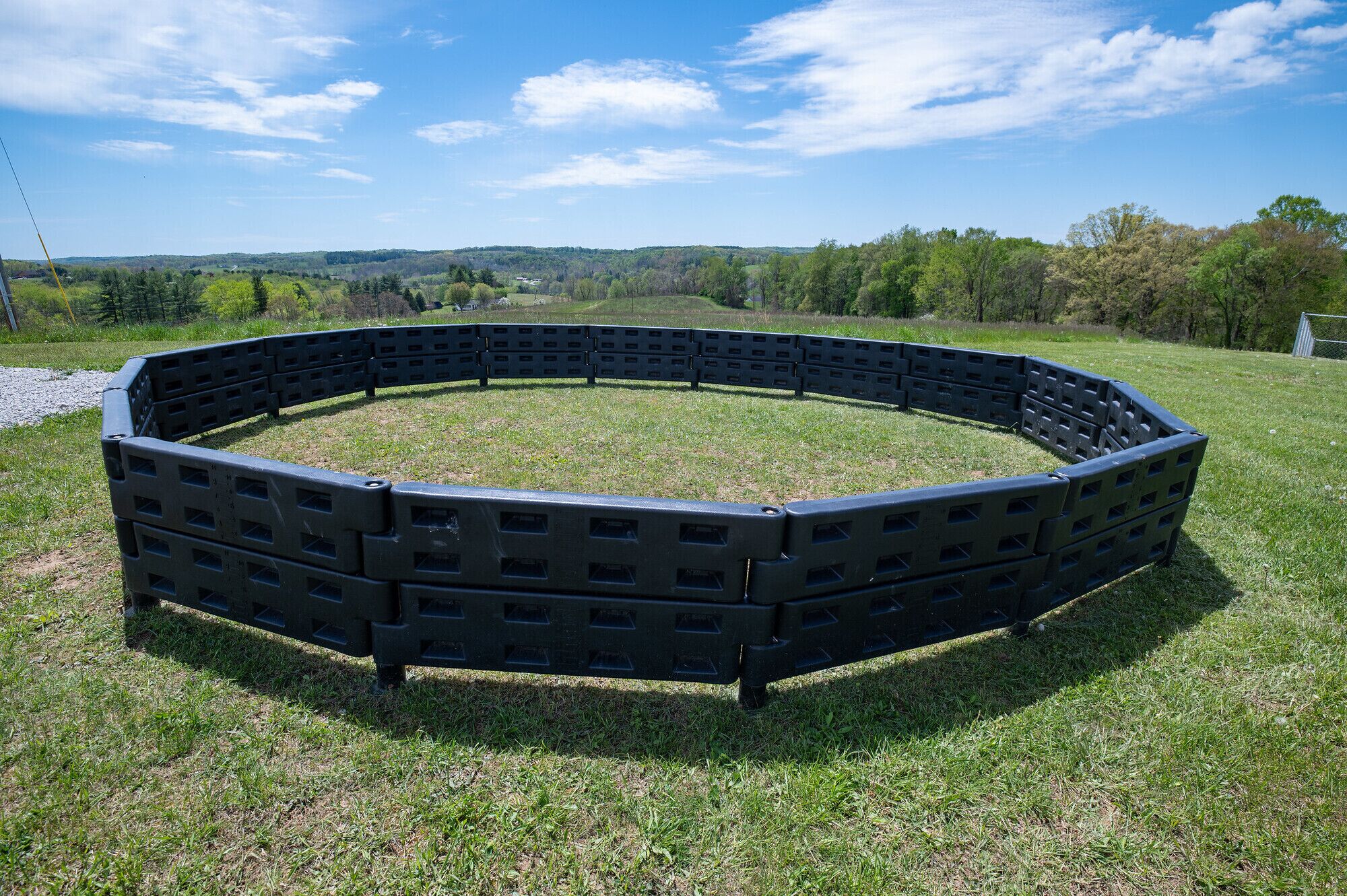 A circular outdoor seating area made of black plastic furniture.