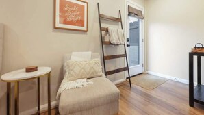 Een gezellige slaapkamer met een bed, een klein rond tafeltje, een trap en een deur die leidt naar een balkon.