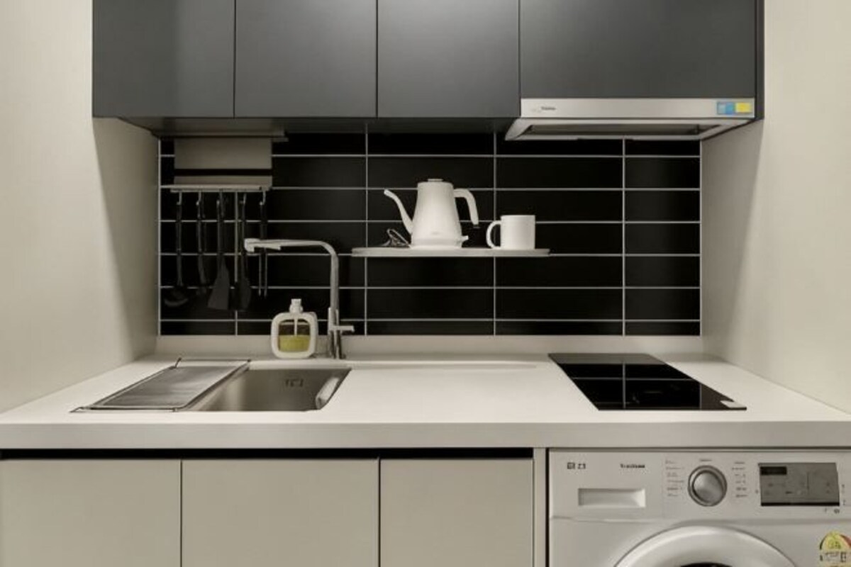 Una cocina moderna con un lavamanos, estufa y lavadora.