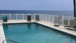 A swimming pool with a white fence and lounge chairs, overlooking the ocean. - Peek-a-boo Ocean View,1bd1bath AC Condo, closer to downtown Kailua village (Kailua-Kona)