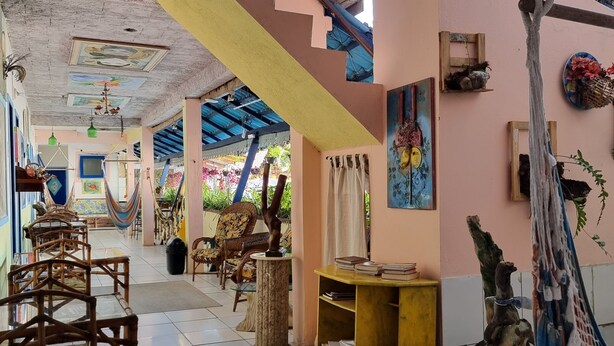 Una habitación amplia con pisos de baldosas, muebles de madera y una hamaca.