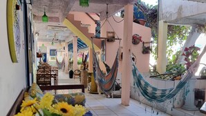 Un amplio patio con una hamaca, un comedor con mesa y sillas, y vista al interior.