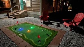 A miniature golf course with a house in the background. - Peachy Beach House - Unit A - Close to beach, game Room, Putting Green, & more! (Gulfport)
