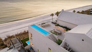 A beachfront property with a swimming pool, outdoor seating, and a view of the ocean. - 'Domus Pacis' | Two Pools, Beach Front,  Next to Seaside 30A (Seagrove Beach)