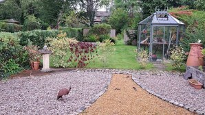 A garden with a gravel path, a greenhouse, and a statue. - Stunning 3BD Victorian House in Bramhall Village (Bramhall)