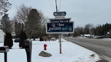 A motel sign for Grand Howell Inn with a Jacuzzi and HD TV.