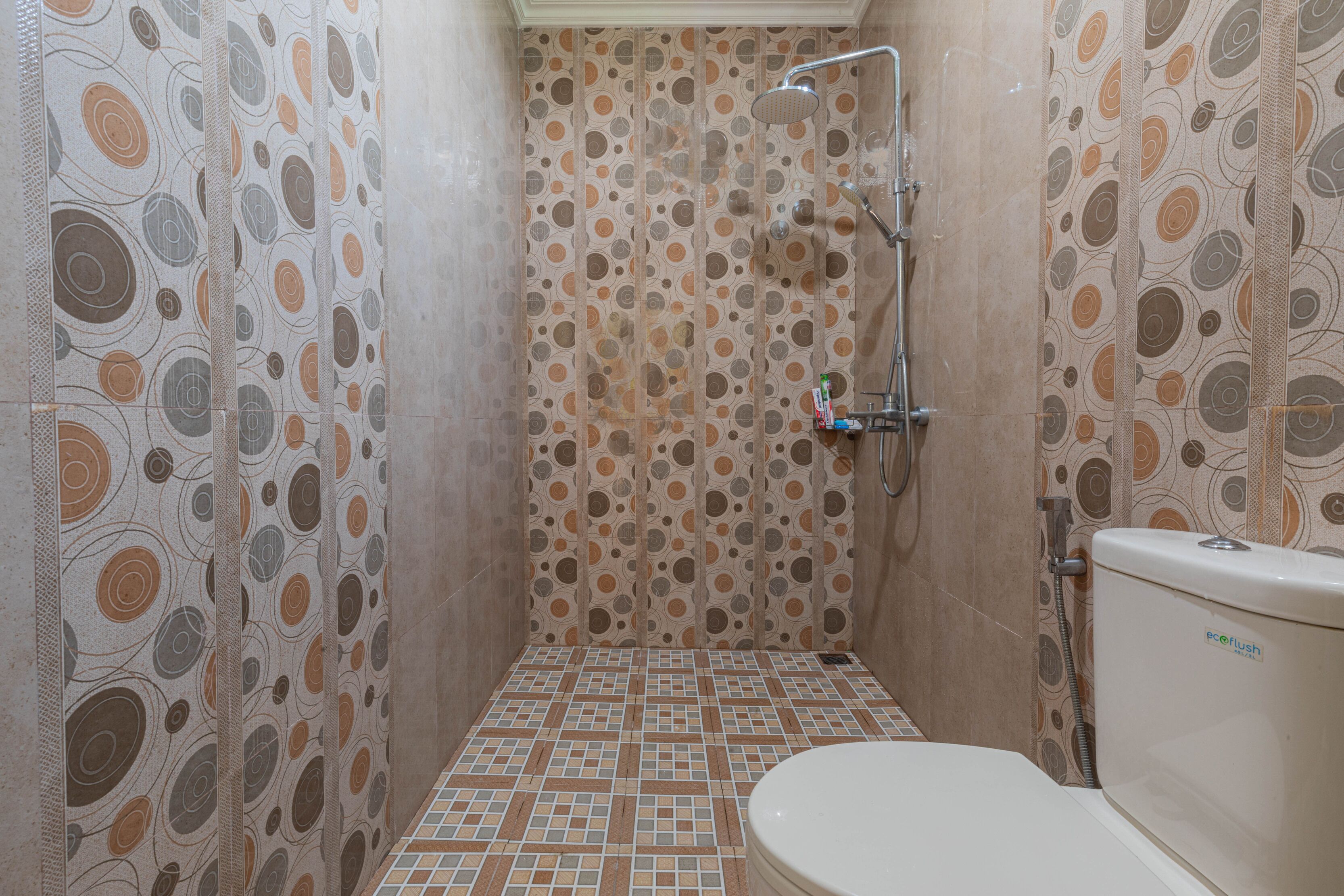 Un baño con paredes decoradas, suelo de baldosas y un inodoro.