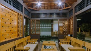 An outdoor seating area with wooden benches and a chess table. - Bait Nahwa  (Narmada)