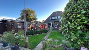 Un jardin bien entretenu, agrémenté d’une clôture en bois, de plantes en pot et d’un chemin dégagé menant à une maison.