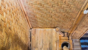 A traditional wooden structure with a woven ceiling and a central wooden beam. - Bale Gantar (Sembalun Lawang)