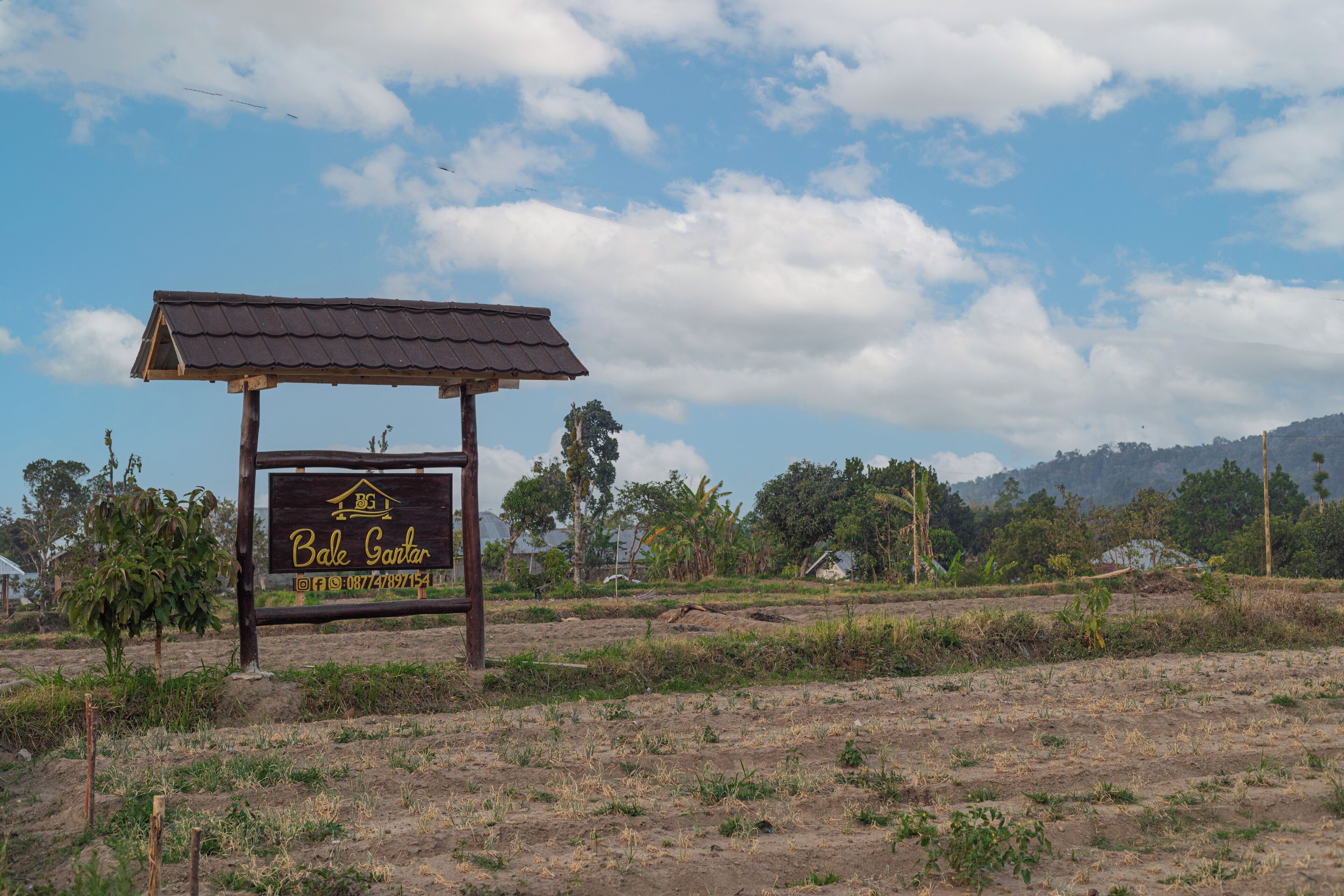 A sign for Bale Santal with a simple structure and a clear view of the surrounding landscape.
