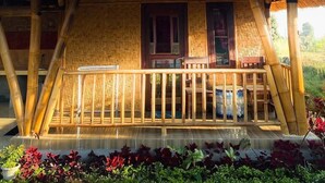 A traditional wooden house with a thatched roof, a balcony, and a tiled porch. - Bale Gantar (Sembalun Lawang)