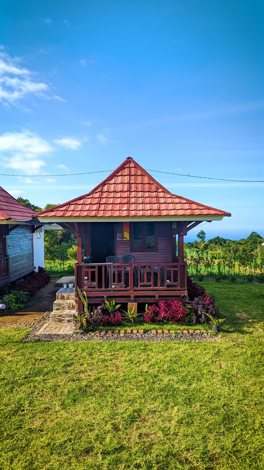 A small house with a red roof and a porch.