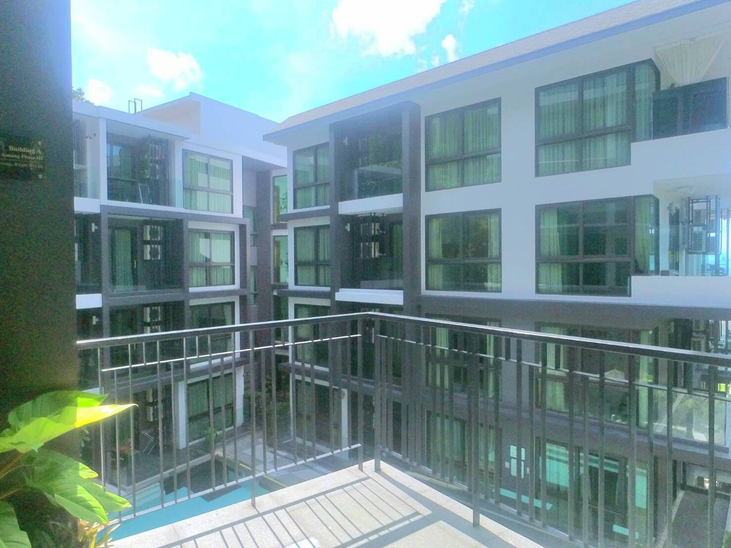 Un edificio moderno con varios pisos, ventanas amplias y un balcón de cristal.