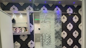 Un bany modern amb paper tapet, un armari de dutxa de vidre i un lavabo amb mirall i prestatgeria.
