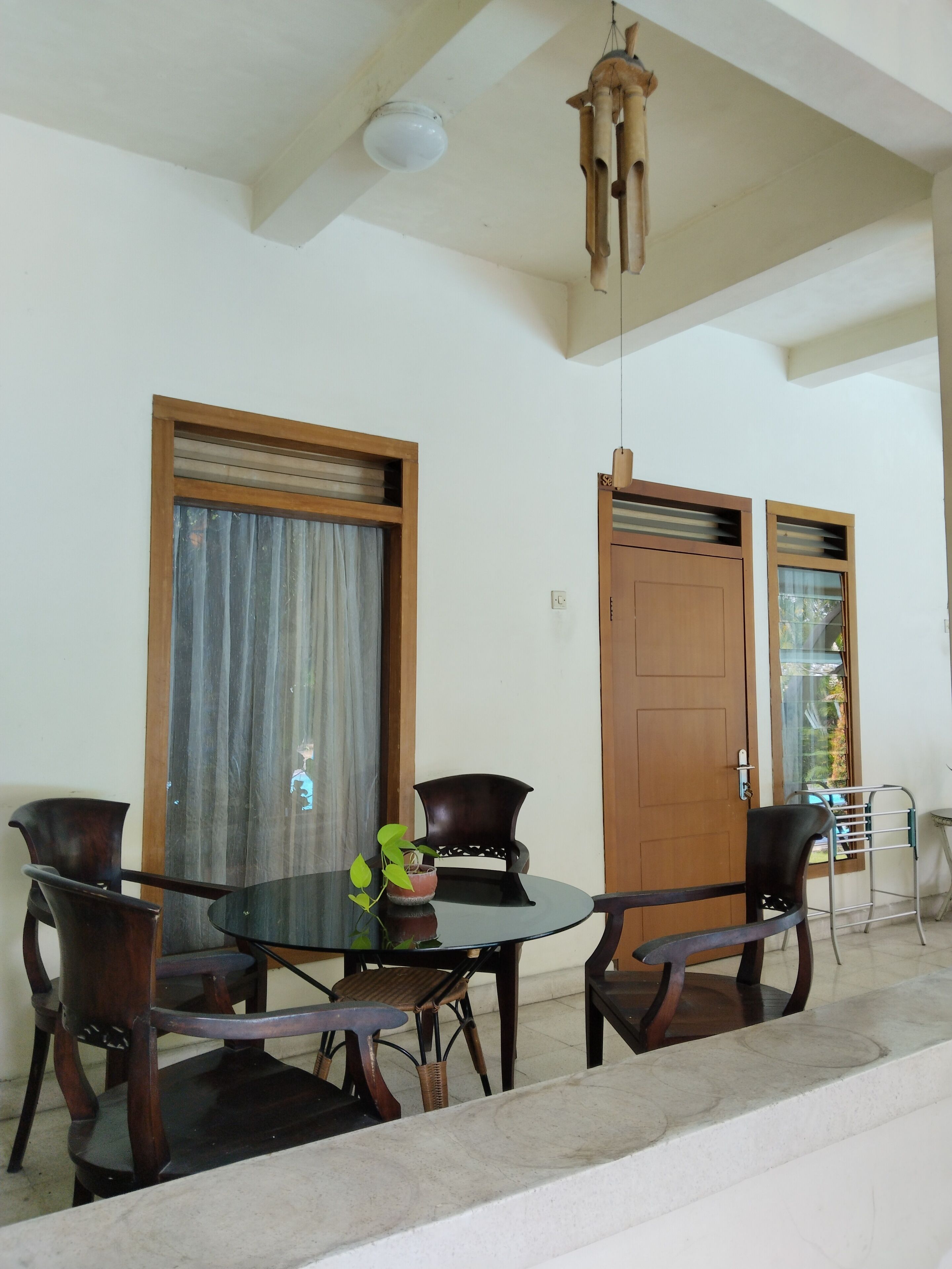 Un coin repas comprenant une table ronde, quatre chaises et un luminaire suspendu.