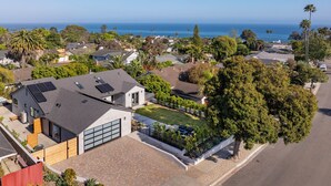 Un quartiere residenziale con case, un garage e vista sull'oceano.