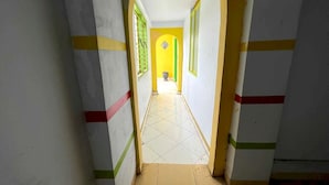 A corridor with tiled flooring and walls painted in white, yellow, and green.