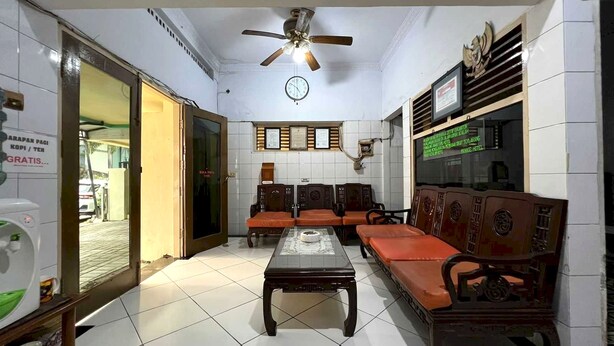 A waiting area with a ceiling fan, a clock, and a wall-mounted TV.
