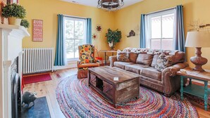 A living room with a sofa, a coffee table, a chair, and a fireplace. - The Shenandoah Suite: Private Balcony, Walkable (Staunton)