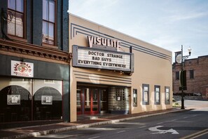 Un teatro con un cartel que anuncia 'VISULITE' y 'DOCTOR STRANGE: MALOS VIVOS, TODO, POR TODAS PARTES'.