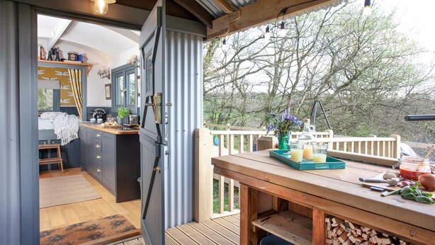 A cozy kitchen with a wooden table and a view of the outdoors.