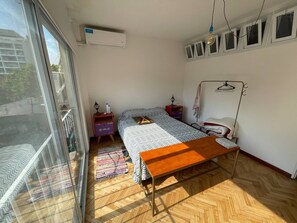 Cozy retreat with a single bed, bedside table, and shelf for personal items.