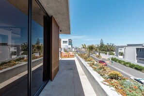 A modern building with a balcony overlooking a street.