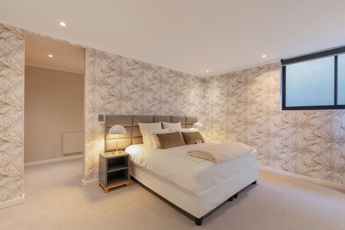 Une chambre à coucher avec un lit, des tables de chevet et une fenêtre.