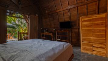 Une pièce en bois avec un lit, un bureau, une chaise et un téléviseur.