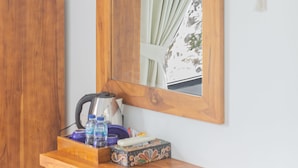A wooden dresser with a mirror above it, a dreamcatcher on the wall, and a window with curtains. - Lahi Villa  (Penida Island)