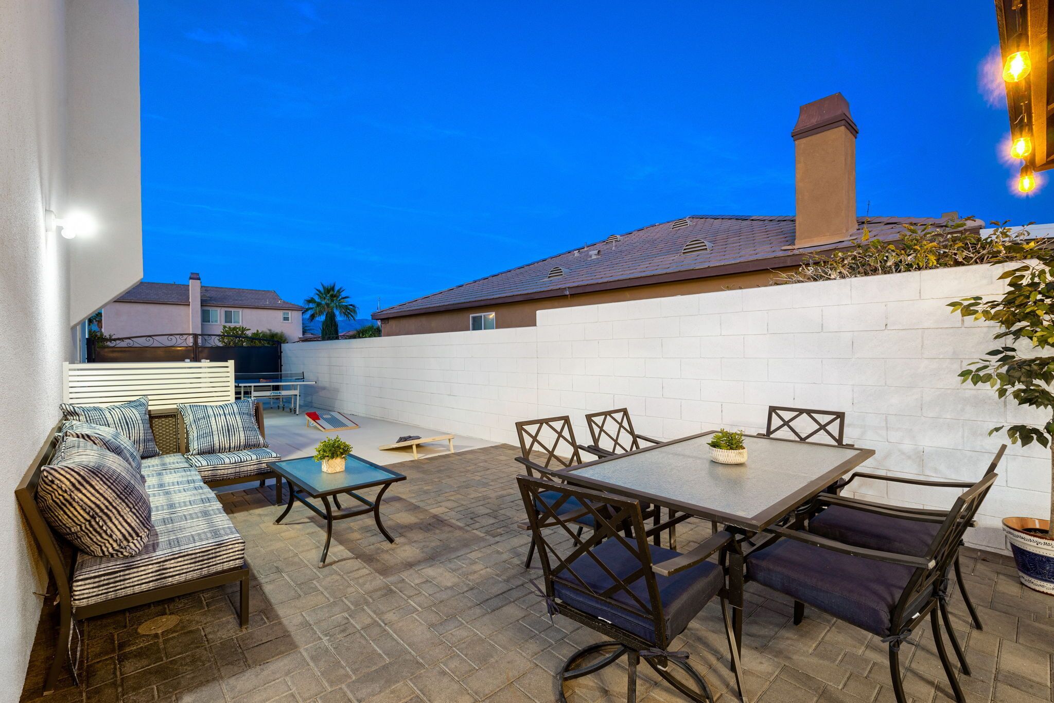 An outdoor patio with a sofa, table, and chairs.
