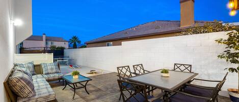 An outdoor patio with a sofa, table, and chairs.