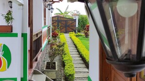 Un sendero estrecho que conduce a una puerta de madera con un farol negro.