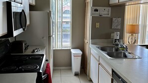 A kitchen with a stove, microwave, refrigerator, sink, and window. - Grand Family Superior 3BD Condo Near Disney 021 (Kissimmee)