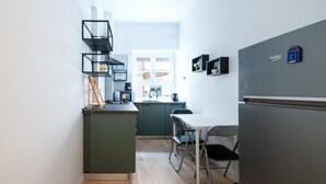 A compact kitchen with a central island, a dining area with a table and chairs, and a refrigerator. - Casa Di Cristina in Rome (Rome)