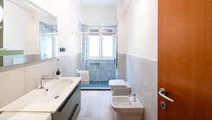 A modern bathroom with a large mirror, two sinks, a toilet, and a shower. - Casa Di Cristina in Rome (Rome)