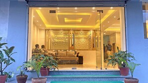 A modern interior with a seating area, glass doors, and potted plants. - Hotel Nilakantha (Kathmandu)