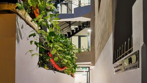 A modern building with multiple floors, a central staircase, and a well-lit interior. - The Galaxy Home Apartment Doi Can (Hanoi)