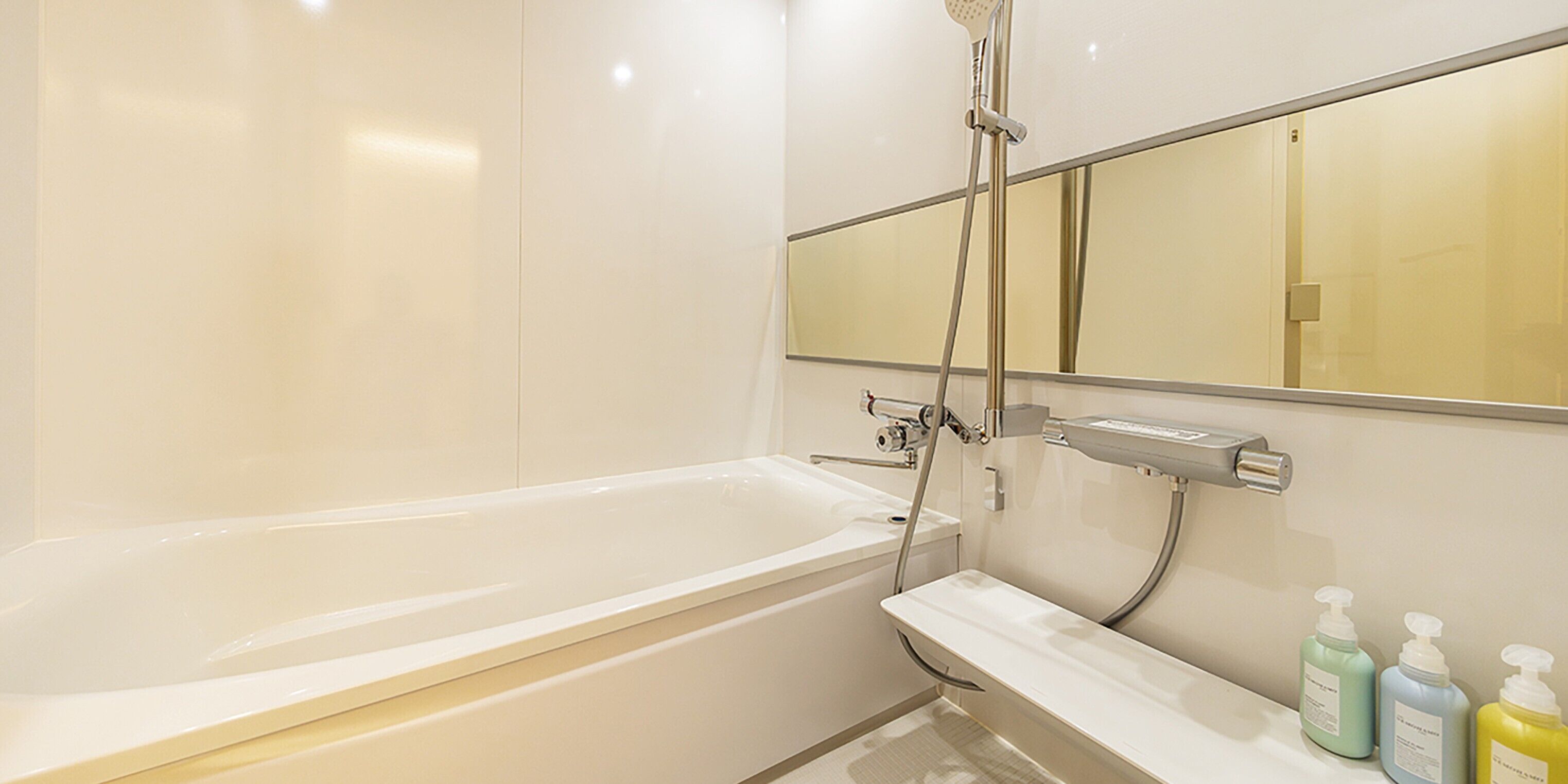 Ein modernes Badezimmer mit Badewanne, Dusche und Waschtisch mit Toilettenartikeln.
