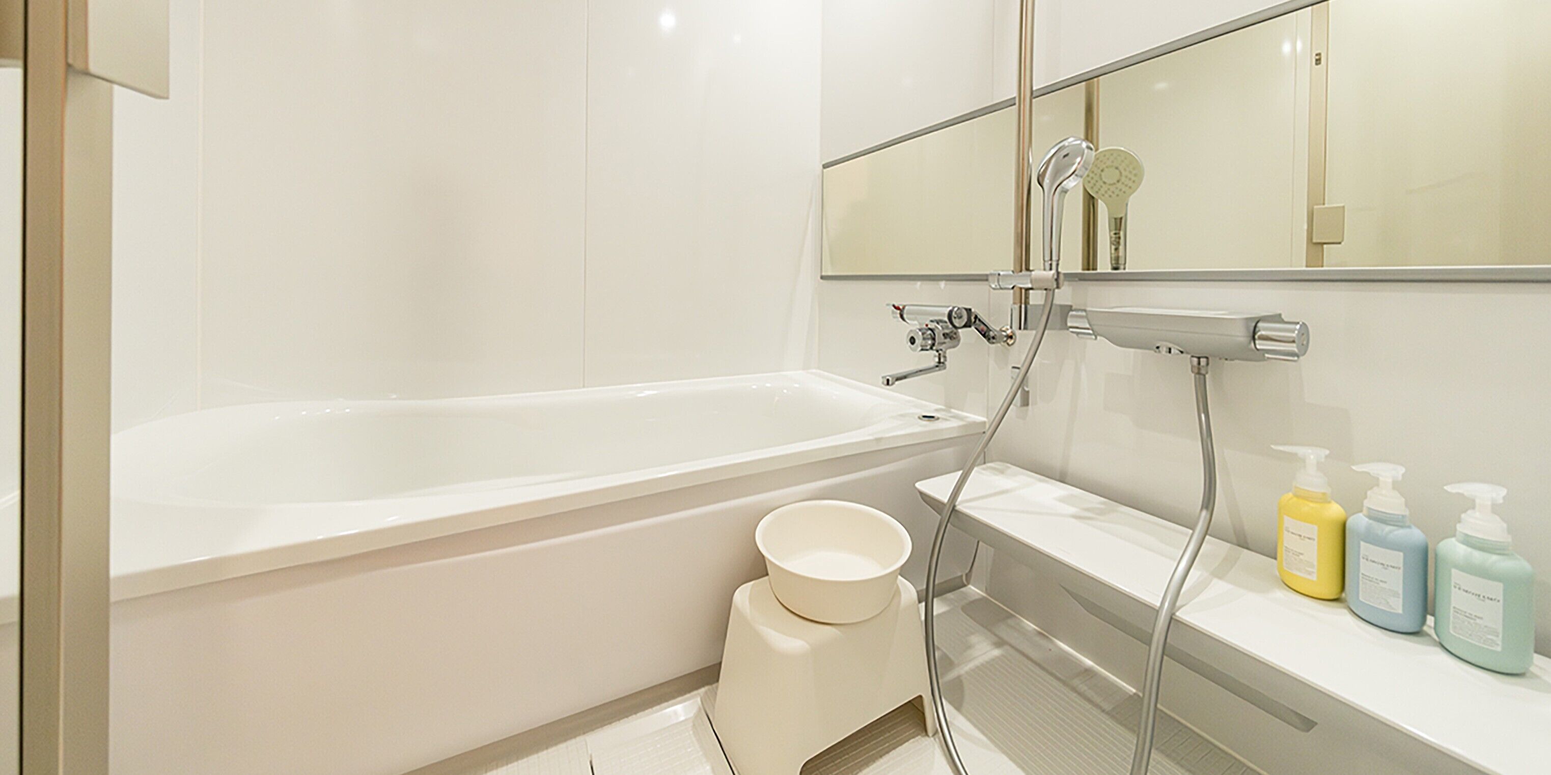 A modern bathroom with a bathtub, a shower, and a vanity with toiletries.