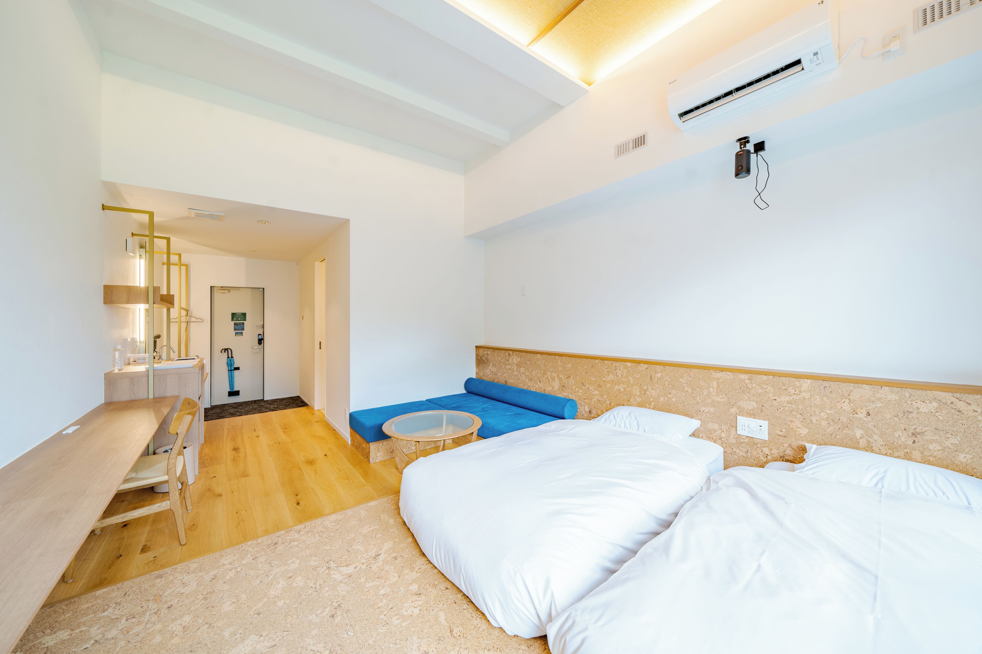Une chambre d’hôtel avec un lit, une petite table, un canapé et un bureau avec une chaise.