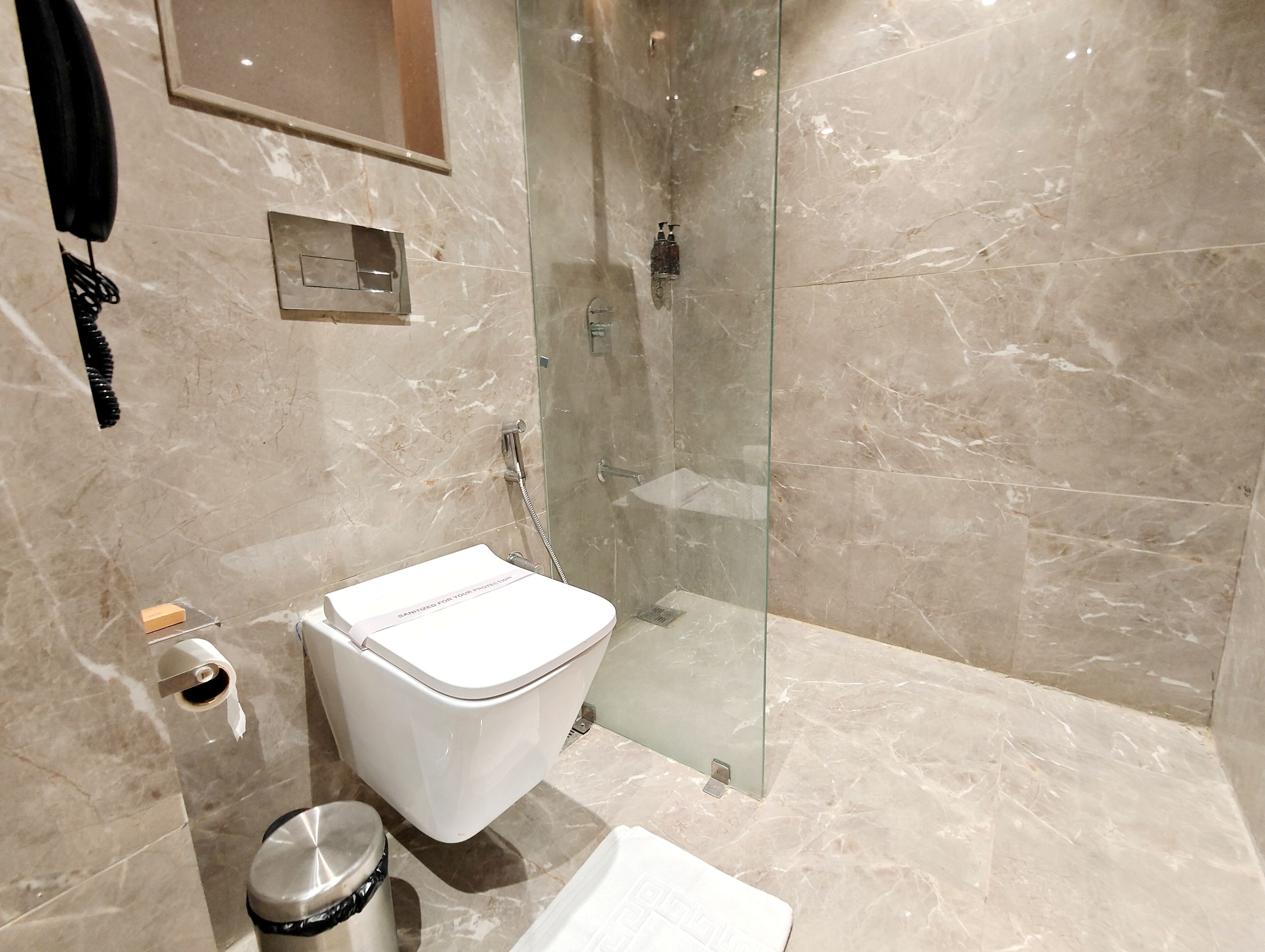 Un baño moderno con inodoro, bidé y cabina de ducha de vidrio.