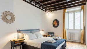 A neatly arranged bedroom with a bed, bedside tables, a desk, and a window with curtains. - Santa Margherita Design Apartment in Navona (Roma)