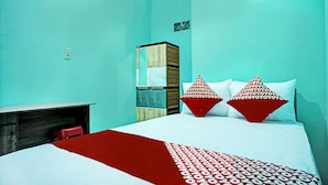 A room with a bed, a desk, and a wardrobe. - Hotel O Barito House (Pematangsiantar)
