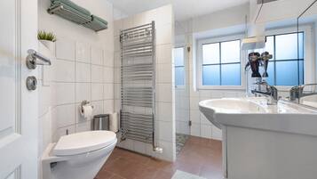 A modern bathroom with a toilet, sink, and towel rack.