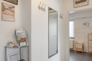 Een hotelkamer met een grote spiegel, een agenda en een klein tafeltje met folders.