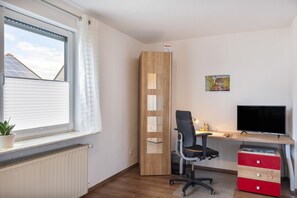 Ein moderner Arbeitsplatz mit Schreibtisch, Stuhl und Computermonitor.