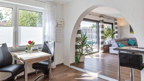 Un espace de vie moderne comprenant un coin repas, un canapé et une vue sur l’extérieur.