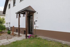 Een gebouw met een witte gevel en een bruin gedeelte beneden.